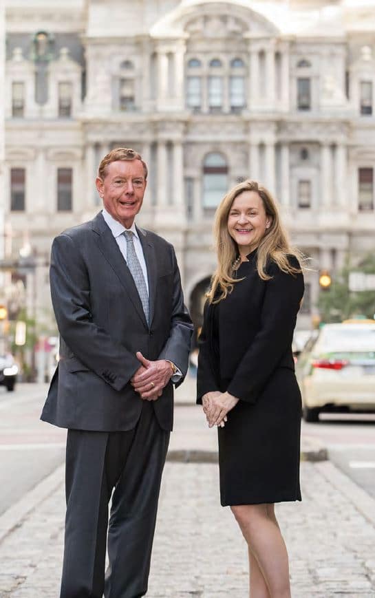 Two business people from 42 Apartment Property Management standing in front of a building.