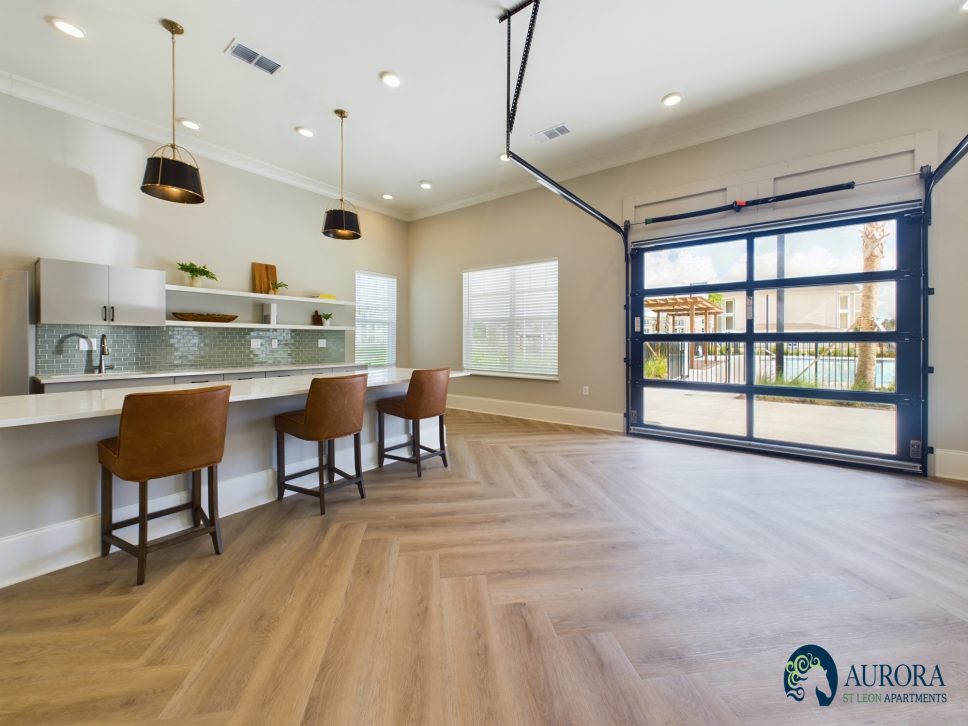 A kitchen with wood floors and a bar area in a 42 Apartment Property Managament building.