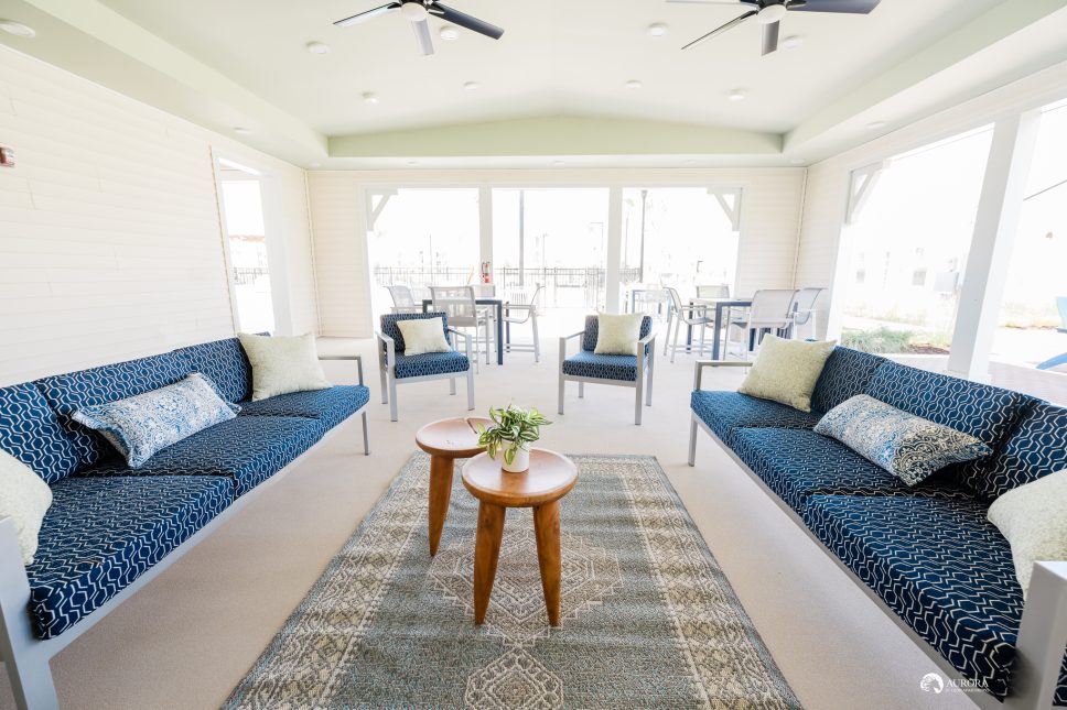 A living room with blue couches and a ceiling fan in a 42 Apartment Property Management.