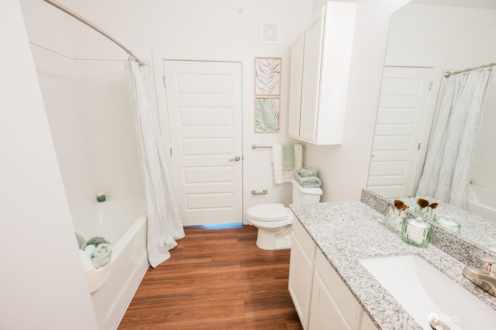 A modern bathroom with a sink, toilet, and shower located in a 42 apartment property managed by professionals.