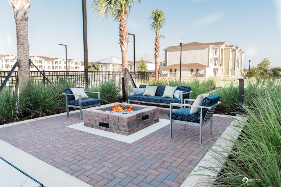 A patio with a fire pit in front of a 42-unit apartment building managed by Apartment Property Management.