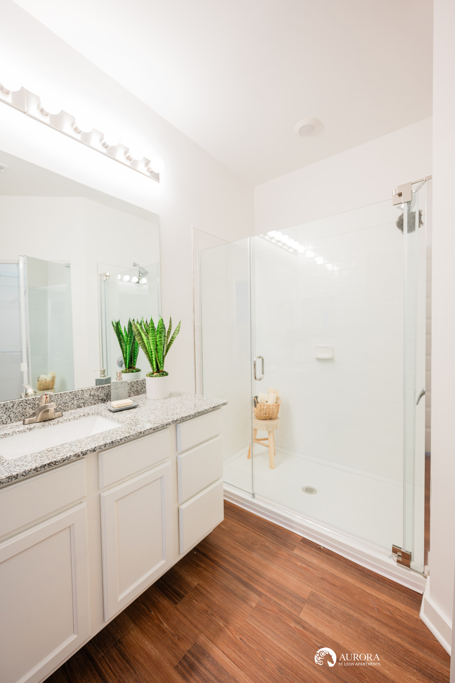 A white bathroom with a glass shower stall in a 42 unit apartment property managed by professionals.