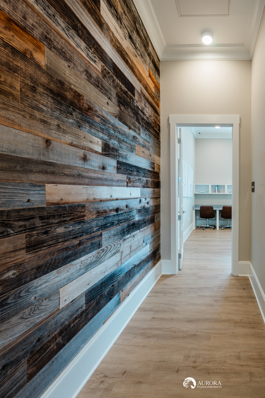 An apartment hallway featuring a wood plank wall.