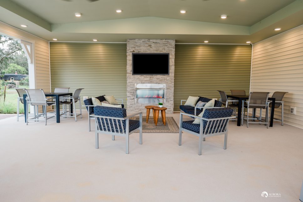 An outdoor living area with a fireplace and a TV, perfect for residents of the 42 Apartment Property Management.